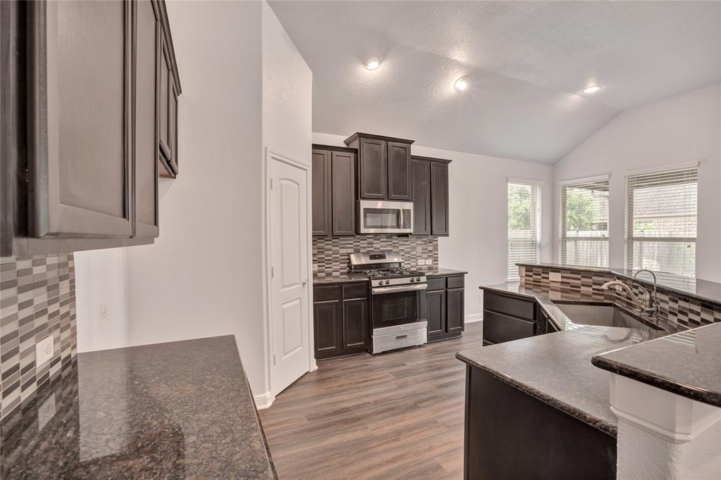 a kitchen with stainless steel appliances granite countertop a sink stove and refrigerator