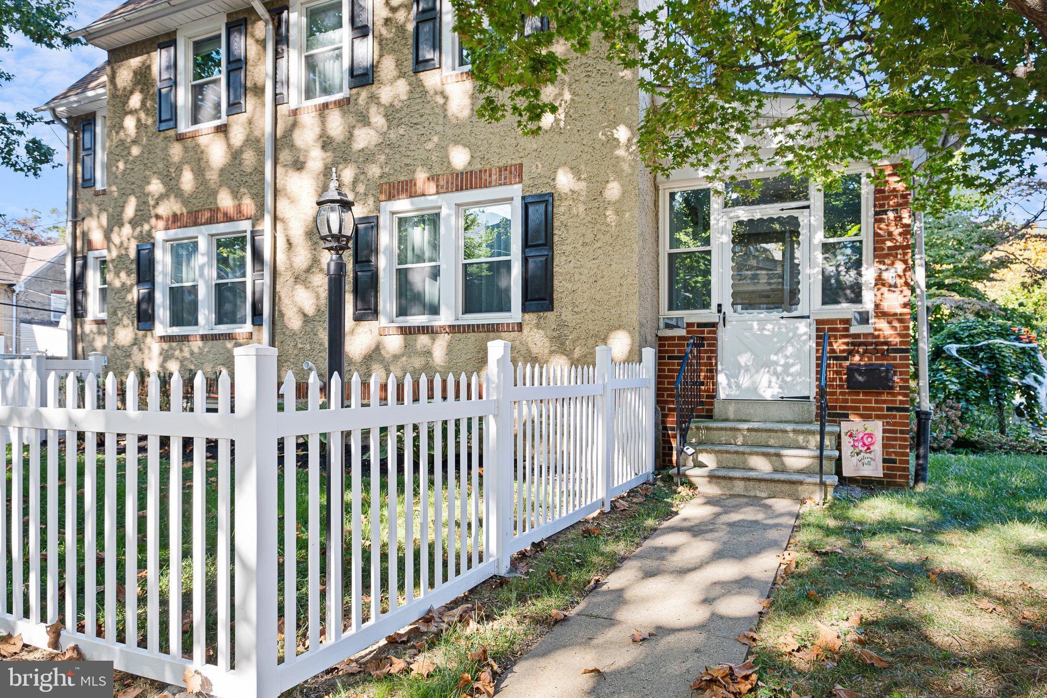 a view of a house with a small yard and wooden fence