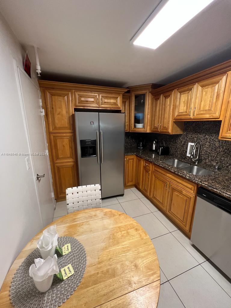 a kitchen with stainless steel appliances a sink and a refrigerator