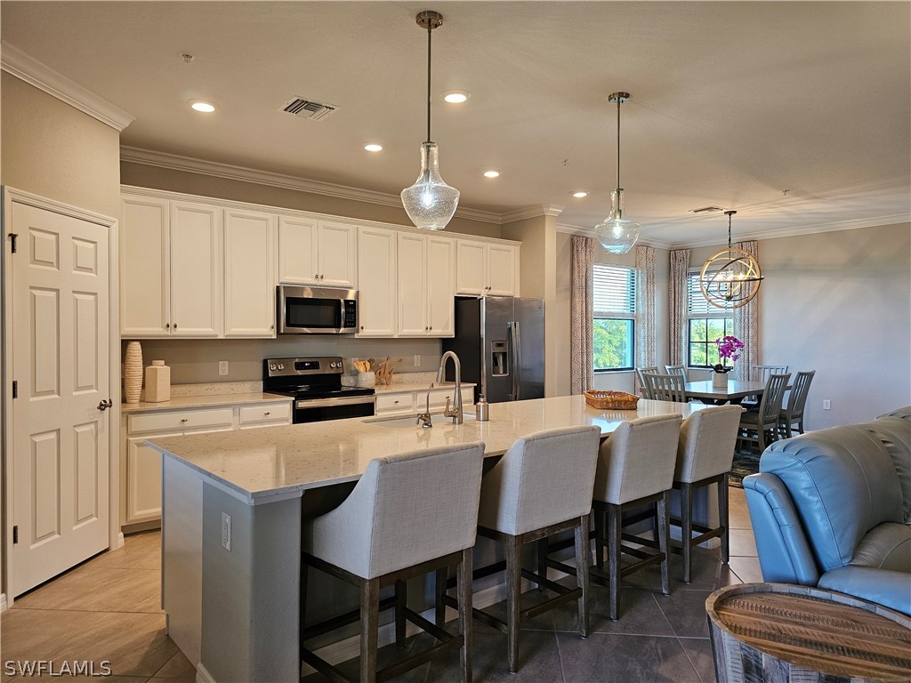 a kitchen with microwave a refrigerator and chairs