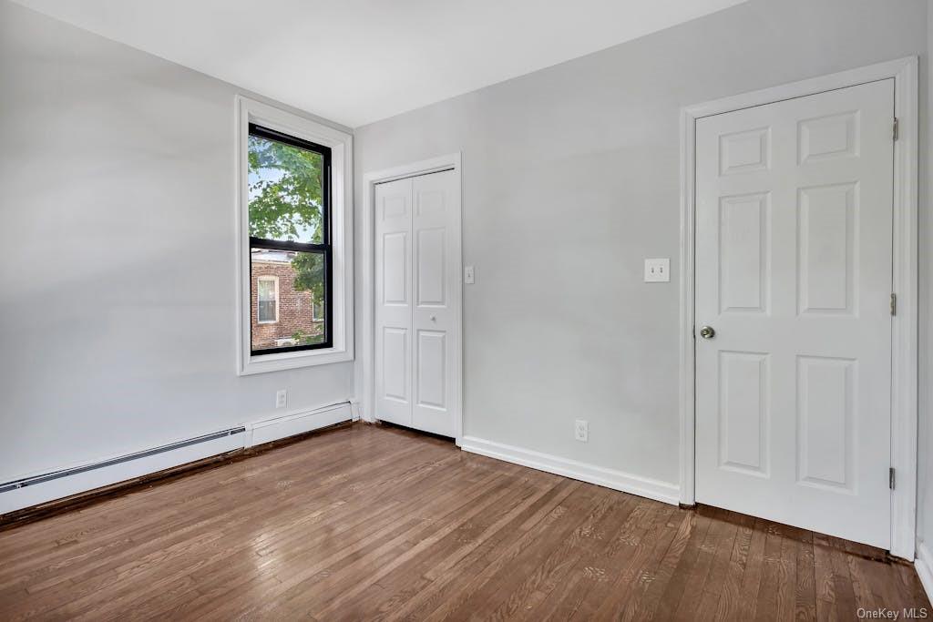 an empty room with wooden floor and window