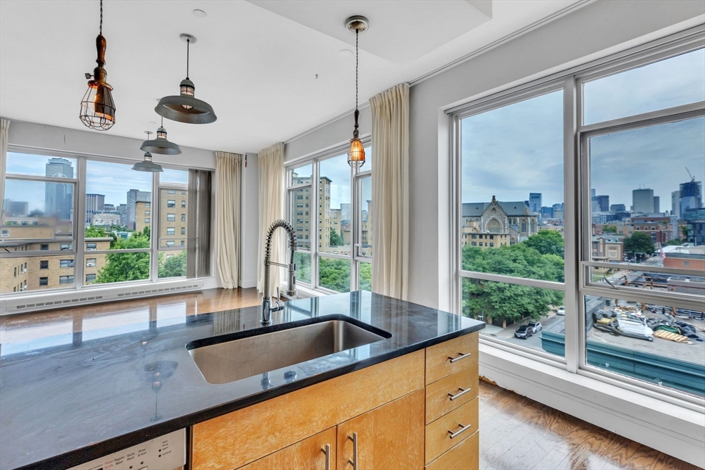 a kitchen with stainless steel appliances granite countertop a sink a counter space and a large window