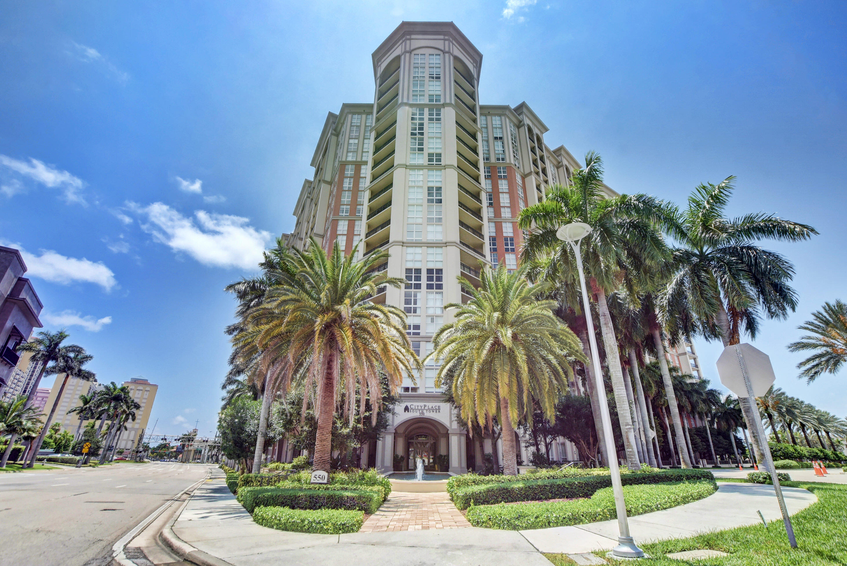 a front view of multi story residential apartment building with yard and green space