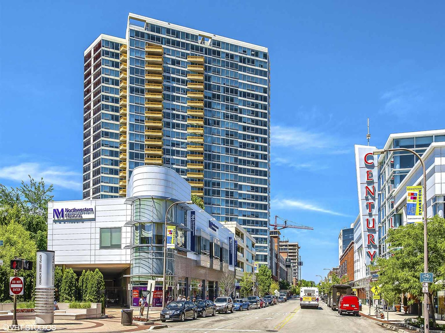 a front view of a building with street view and trees