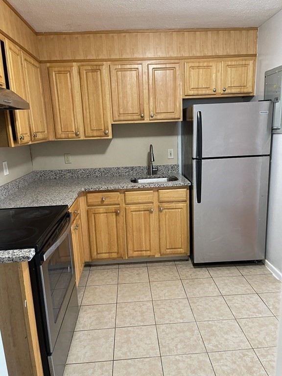 a kitchen with a refrigerator a stove a sink and a window