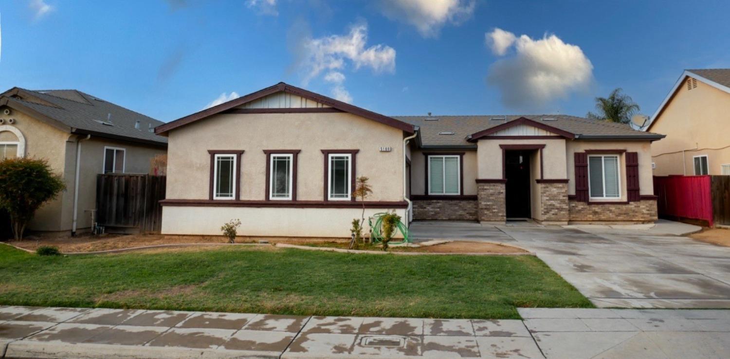 a view of a house with a yard and sitting area