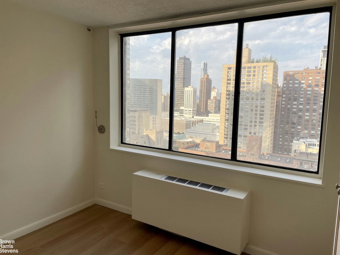 a view of a room with wooden floor and a window