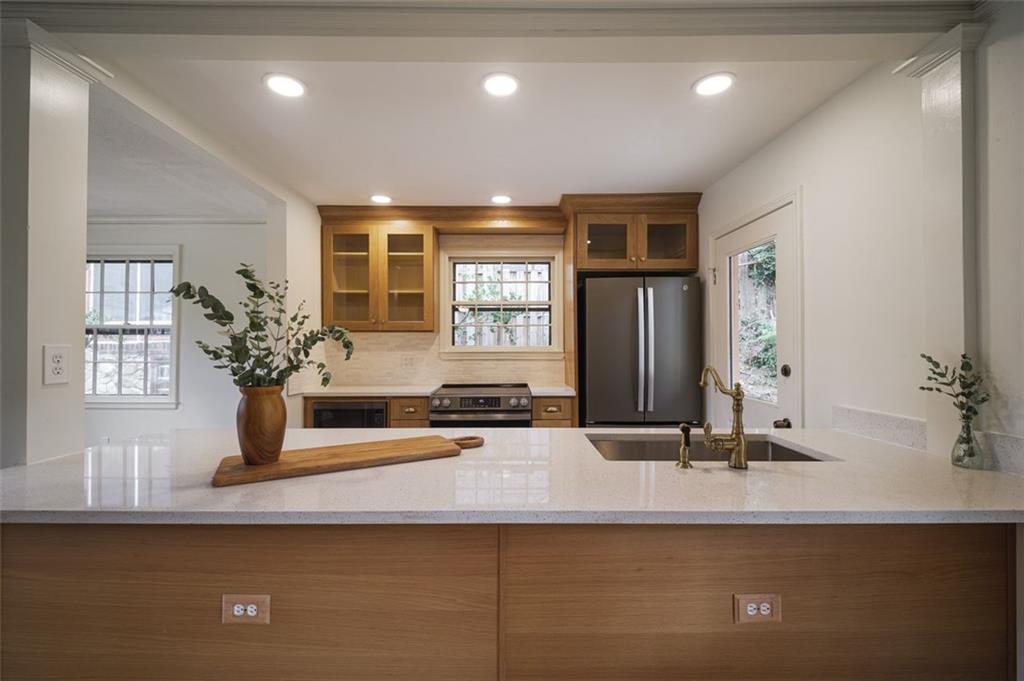 a kitchen with kitchen island a sink stainless steel appliances and a counter top space