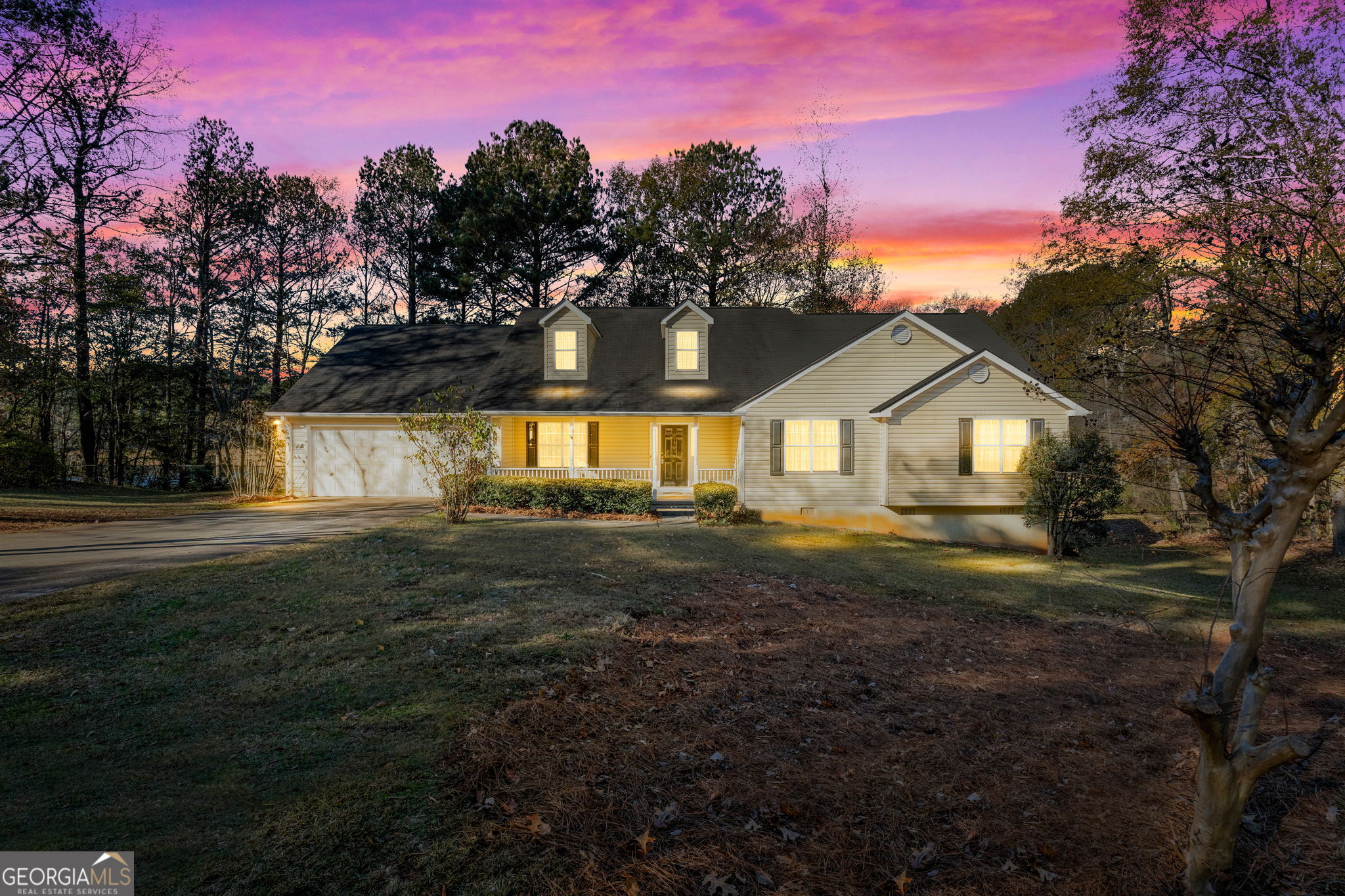 a front view of a house with yard and green space