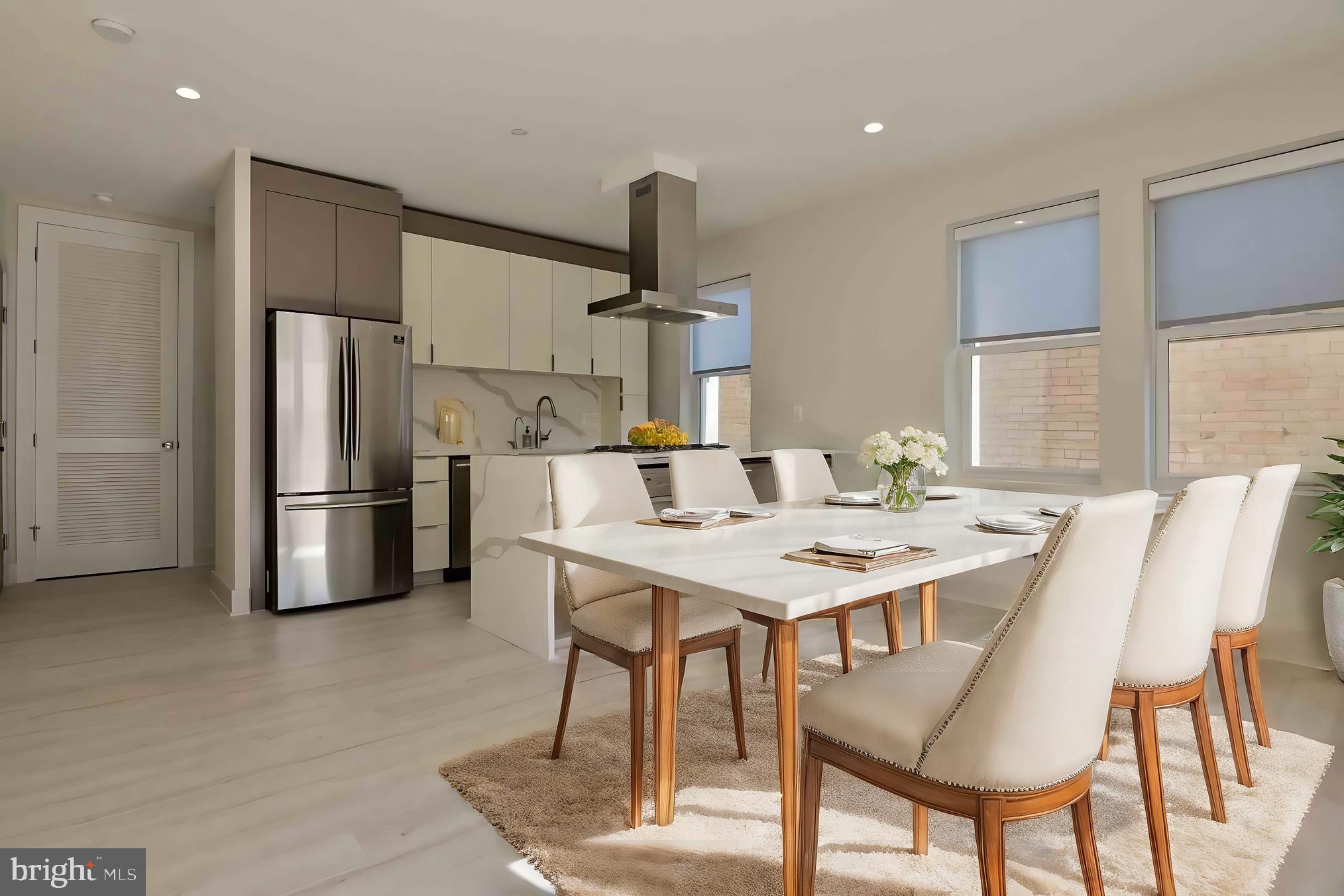 a kitchen with stainless steel appliances kitchen island a table chairs and microwave