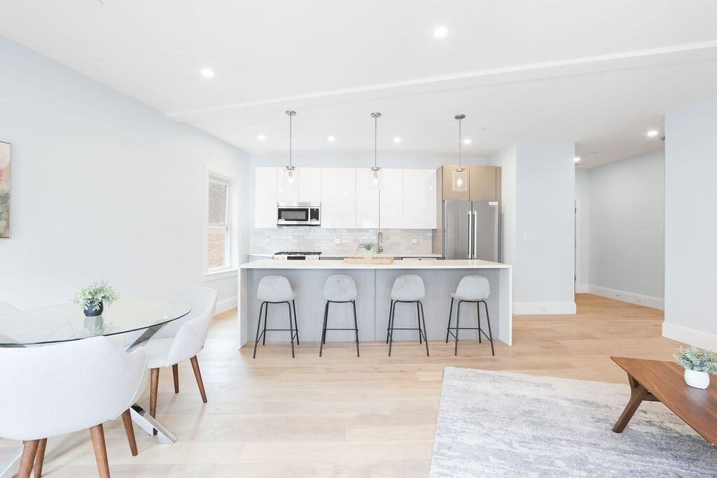 a view of kitchen with stainless steel appliances cabinets table and chairs