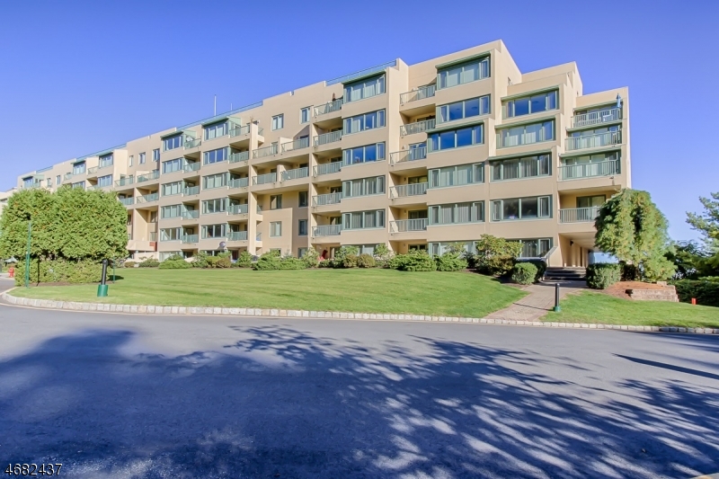 a view of a tall building next to a yard