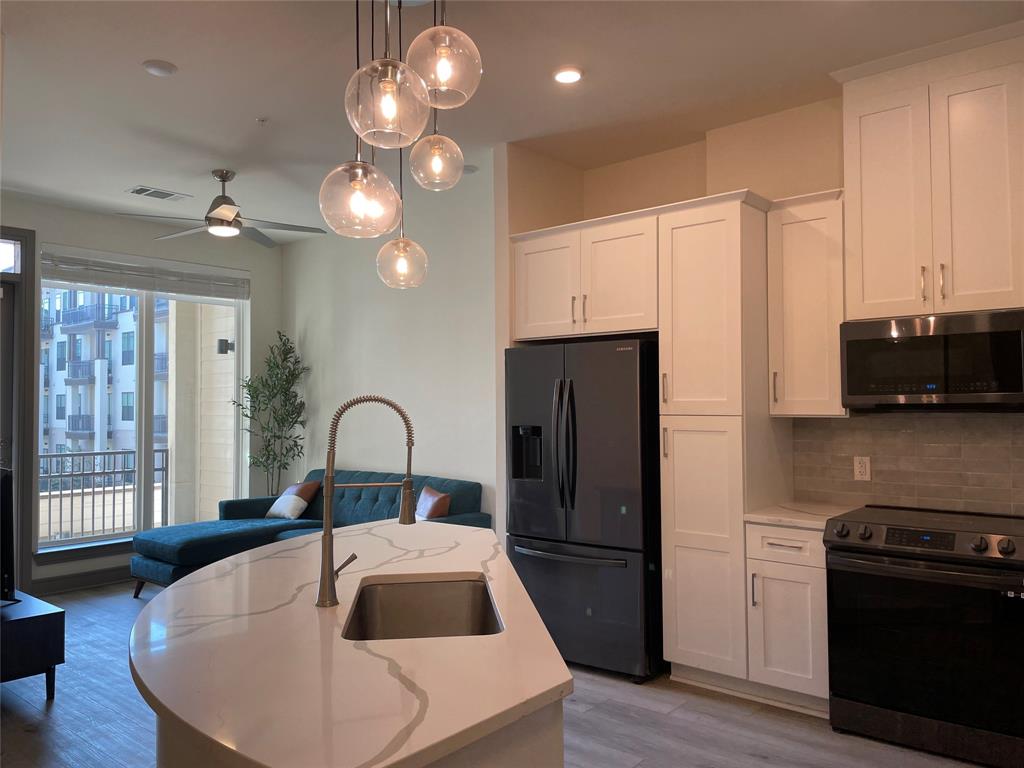 a kitchen with refrigerator a stove and a wooden floor