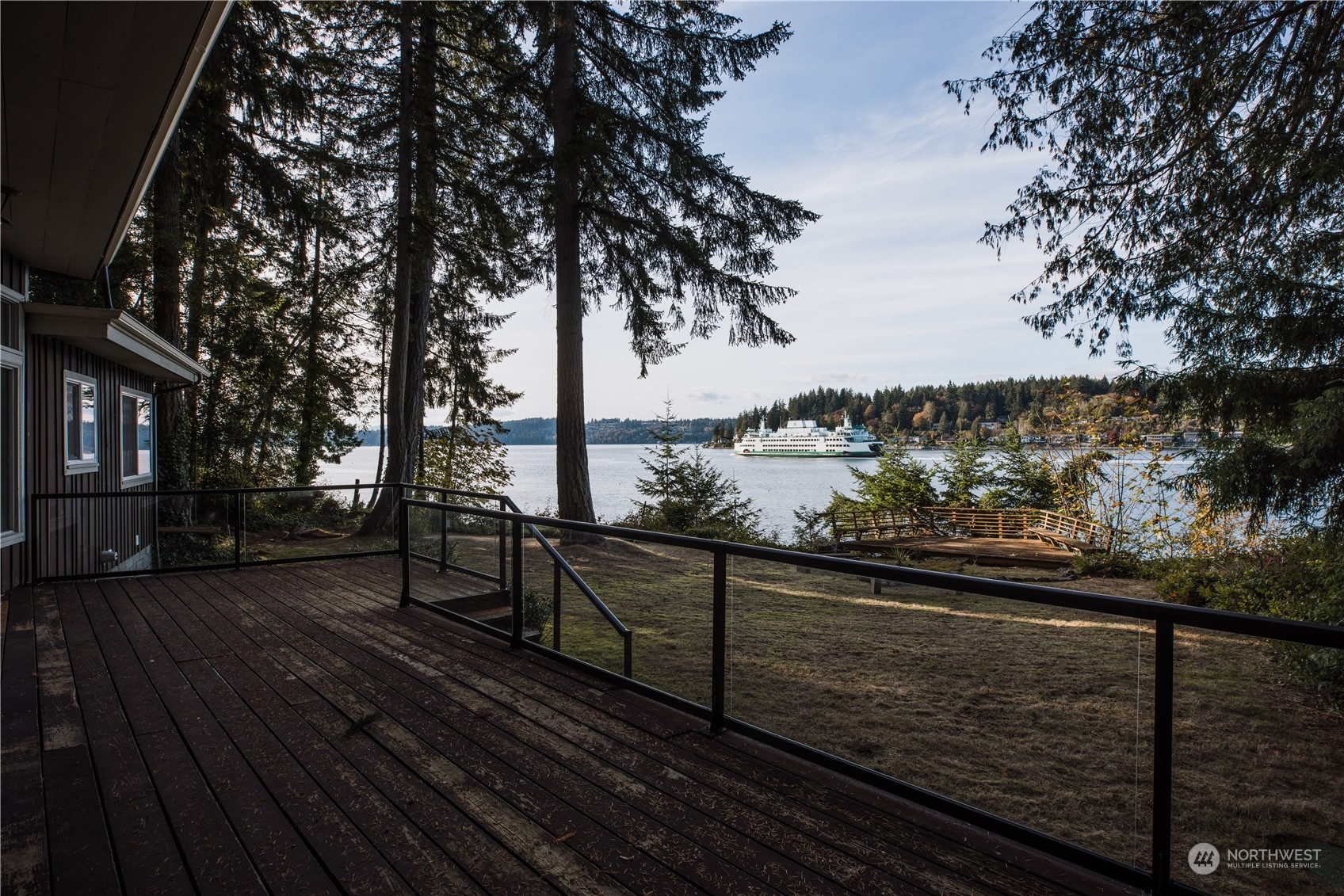 a view of a balcony with wooden floor and fence and trees