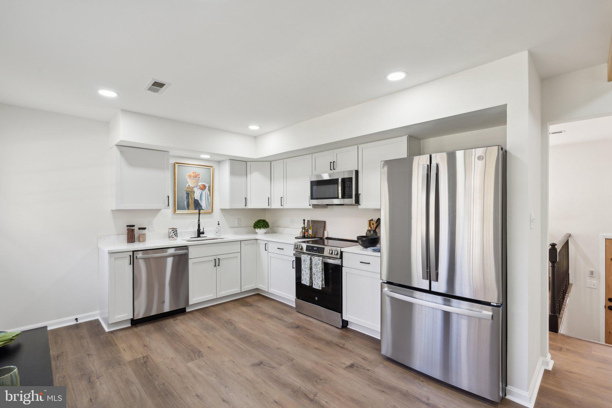 a kitchen with white cabinets and stainless steel appliances