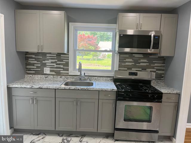 a kitchen with granite countertop a stove and a sink