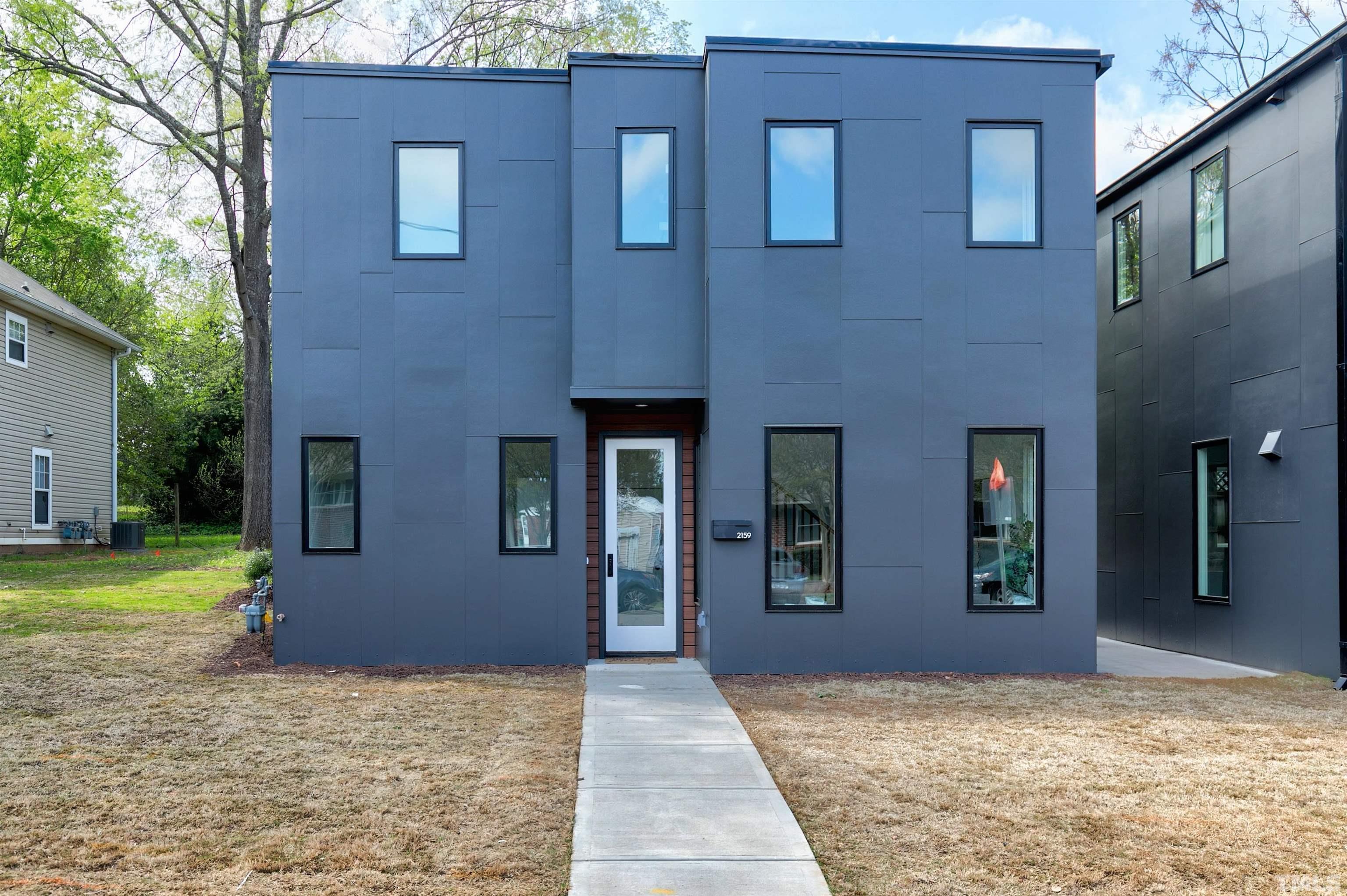 a view of a house with many windows and a yard