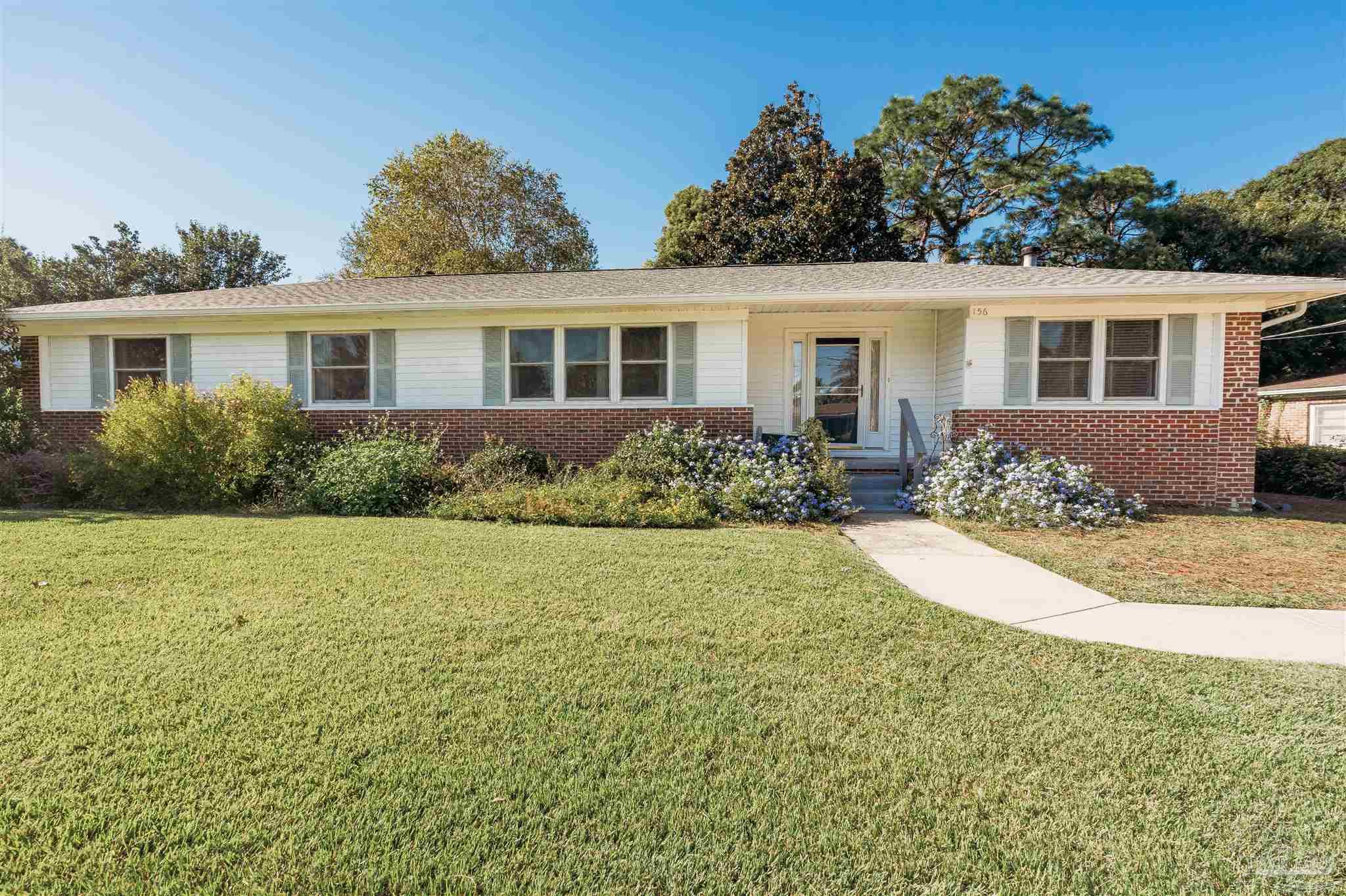 a front view of a house with yard and green space