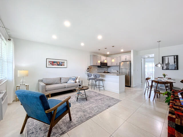 a living room with lots of furniture and kitchen view