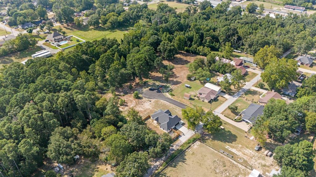 an aerial view of residential house with outdoor space and trees all around