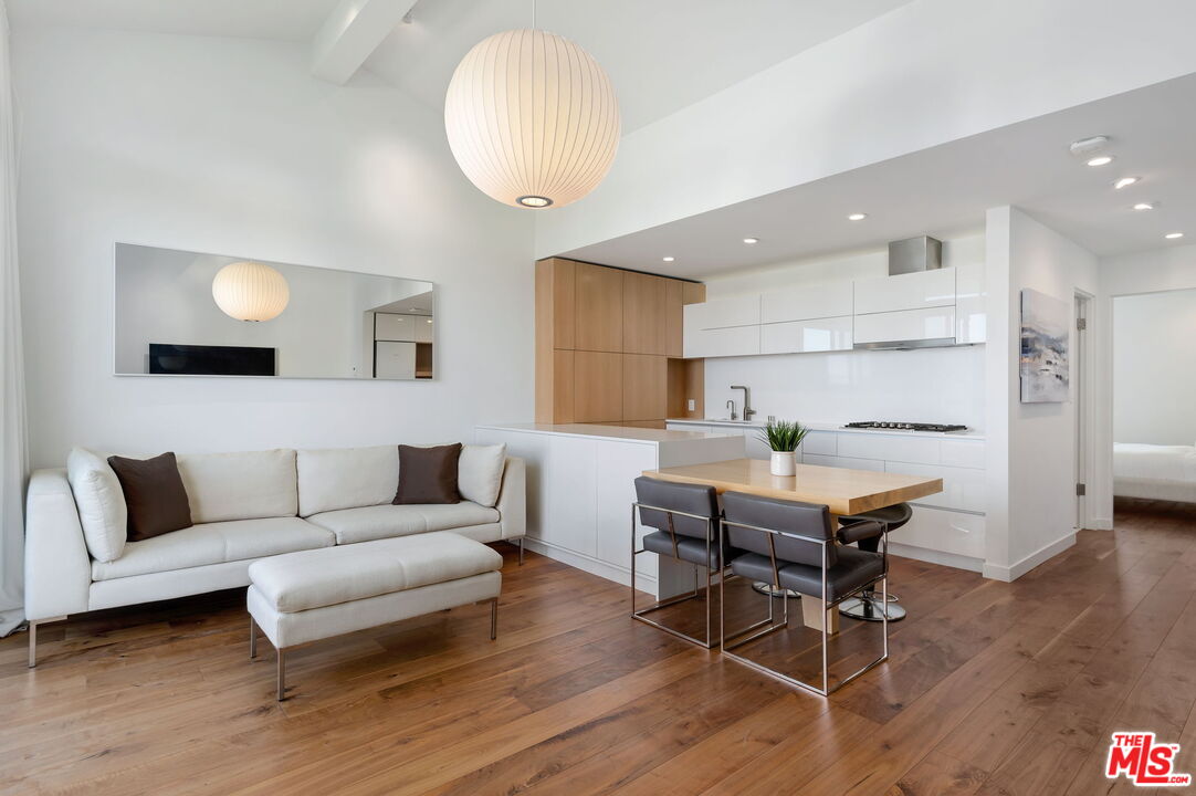 a living room with furniture a wooden floor and a large window