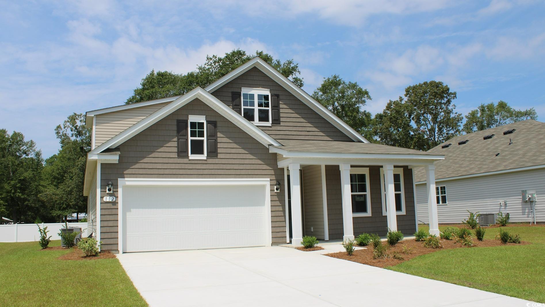 Craftsman inspired home with a front yard and a ga