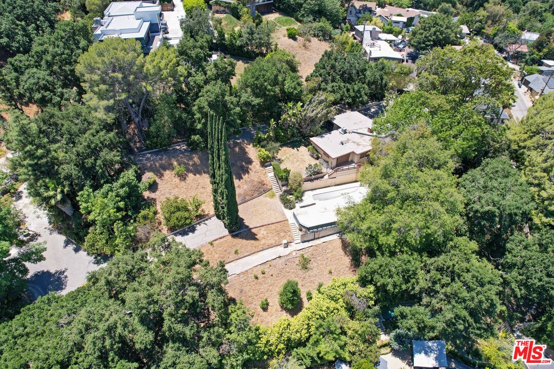 an aerial view of residential house with outdoor space and trees all around