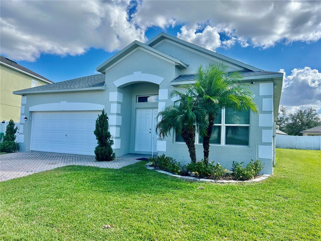 a front view of a house with a yard and garage