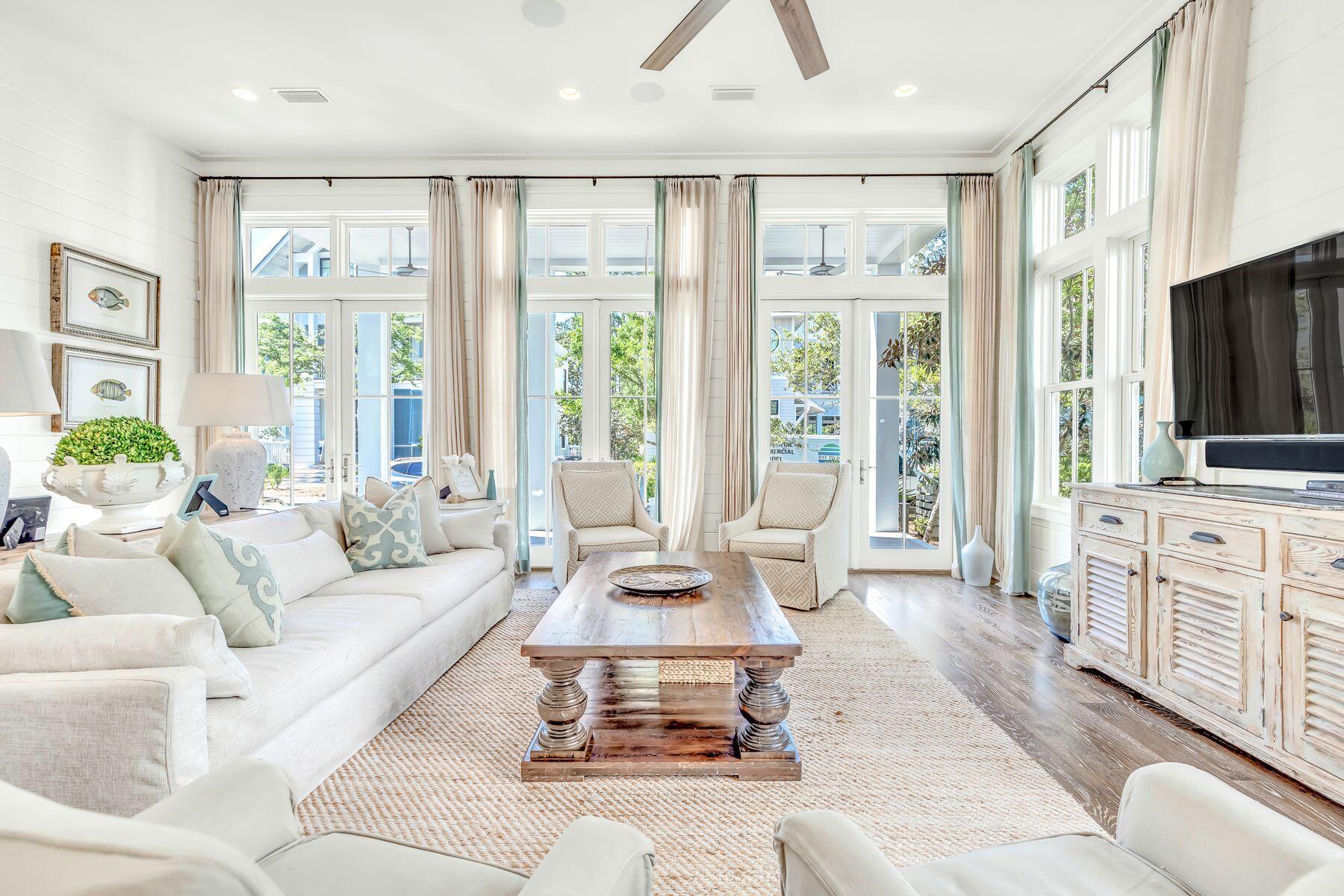 a living room with furniture large window and flat screen tv