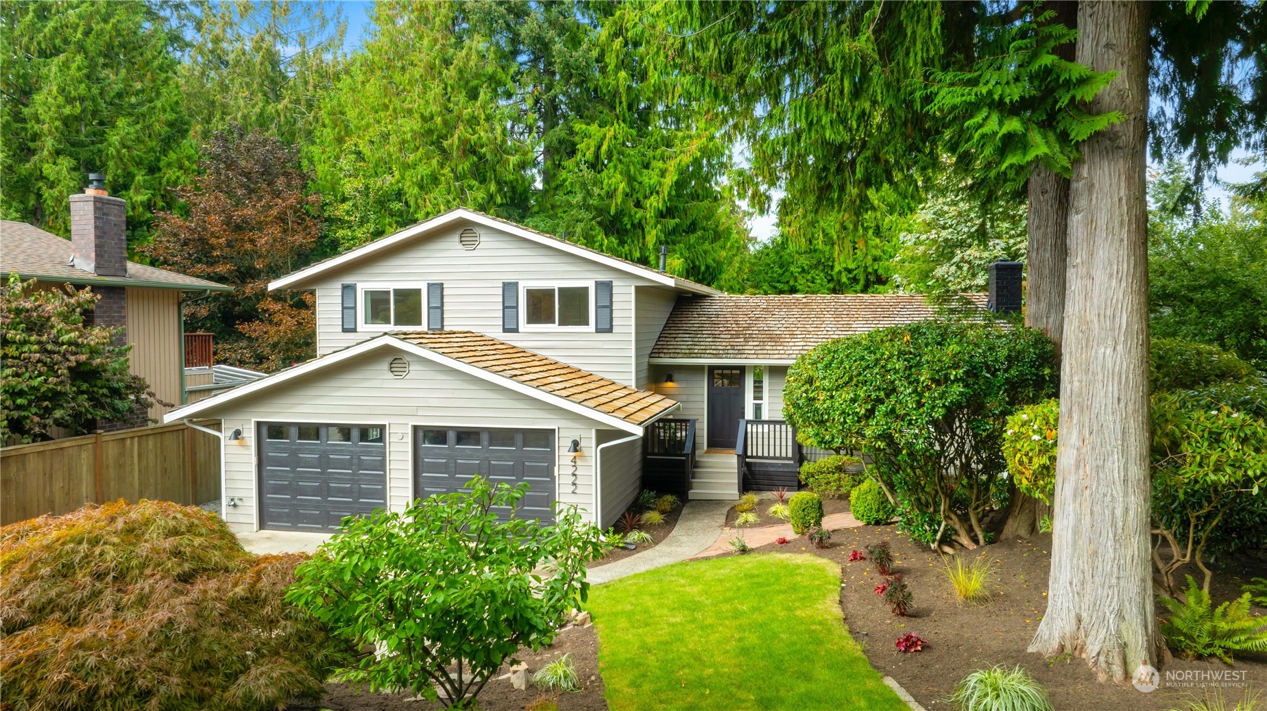 a front view of a house with a yard and potted plants