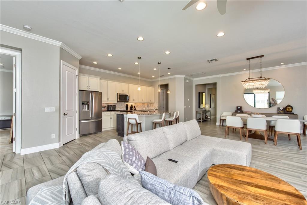 a living room with furniture and a dining table with kitchen view