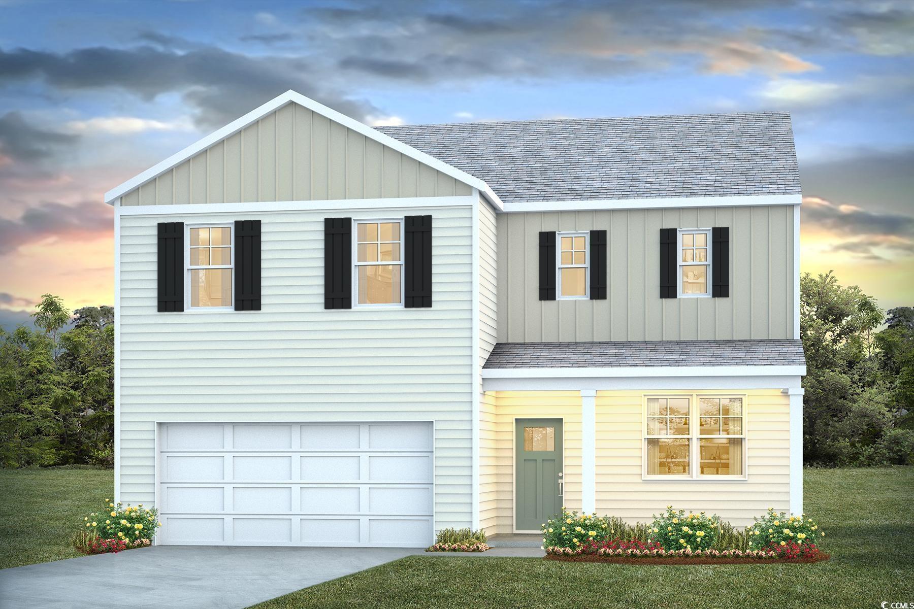 View of front of house with a garage and a lawn