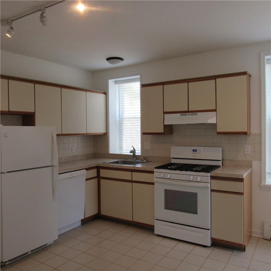 Kitchen featuring gas range, dishwasher, fridge an beautiful cabinets and countertops