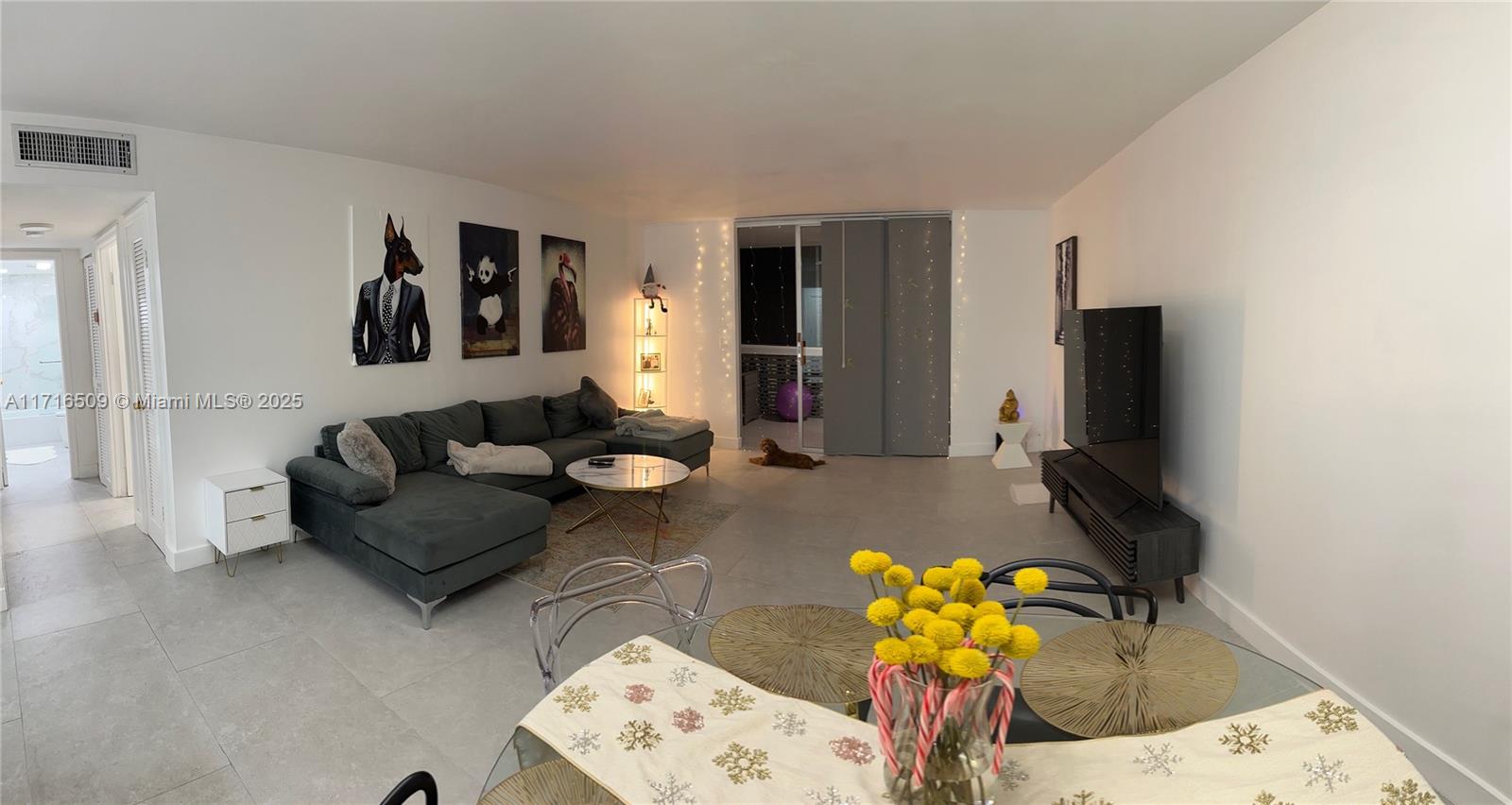 a living room with furniture flowerpot and a chandelier