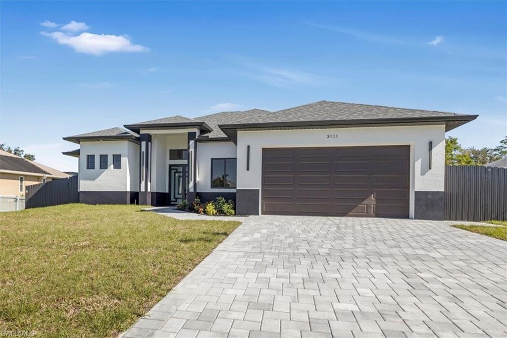 View of front of house featuring a garage and a front lawn