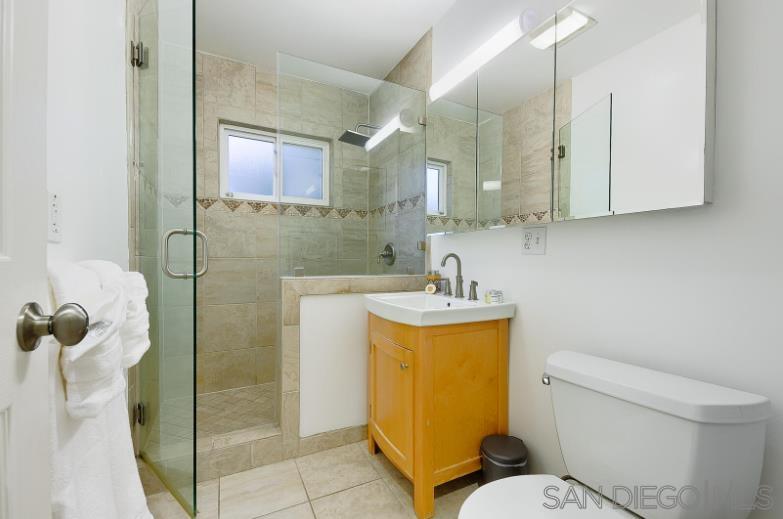 a bathroom with a granite countertop toilet sink and mirror