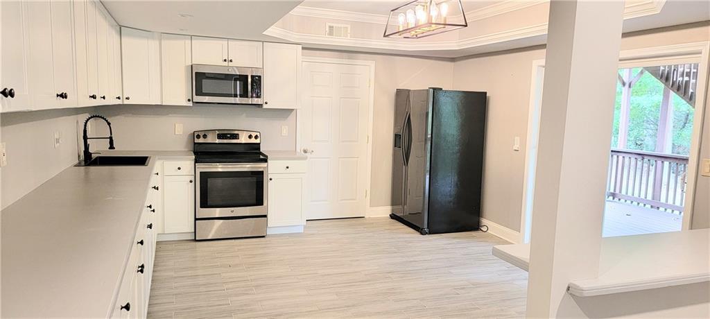 a kitchen with stainless steel appliances a stove microwave and refrigerator