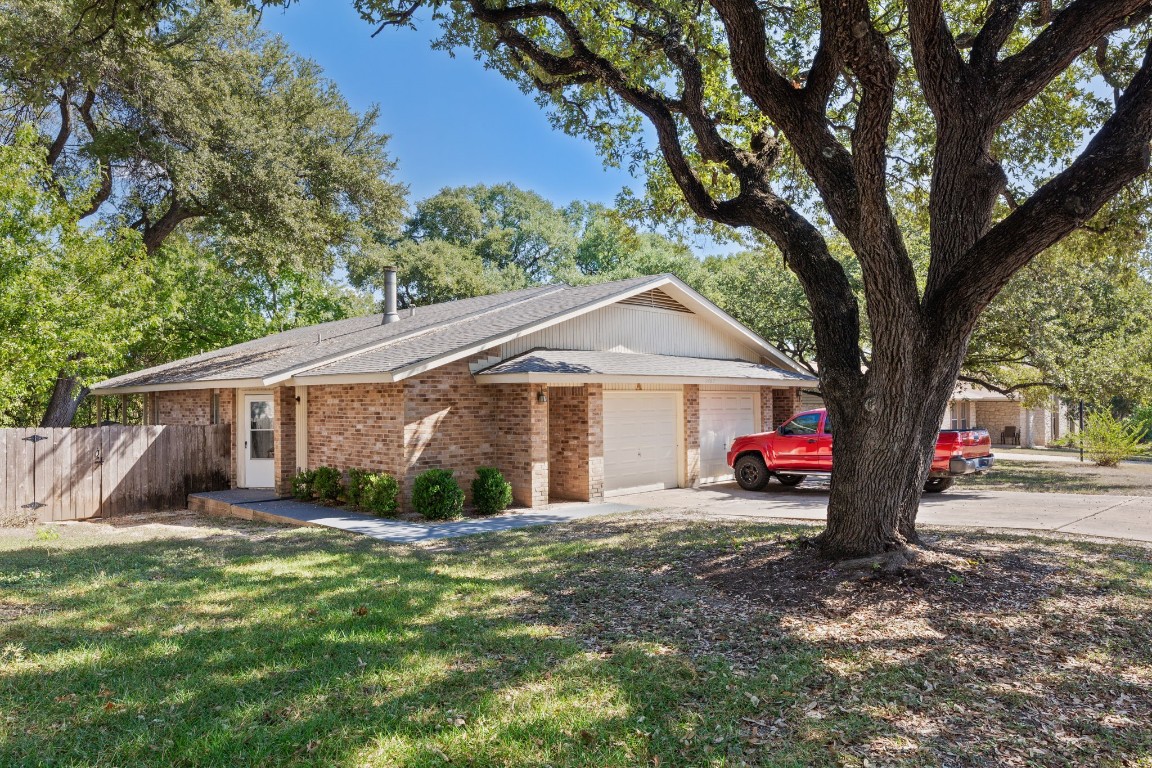 a view of a house with a yard and tree