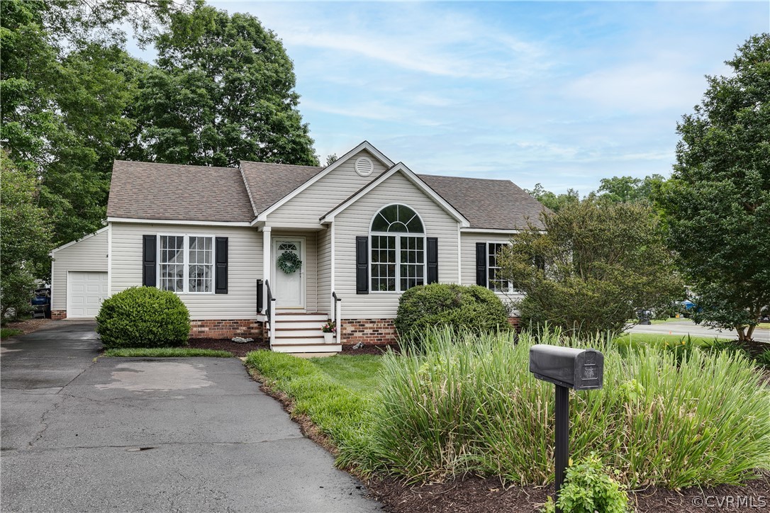 a front view of a house with a yard and potted plants