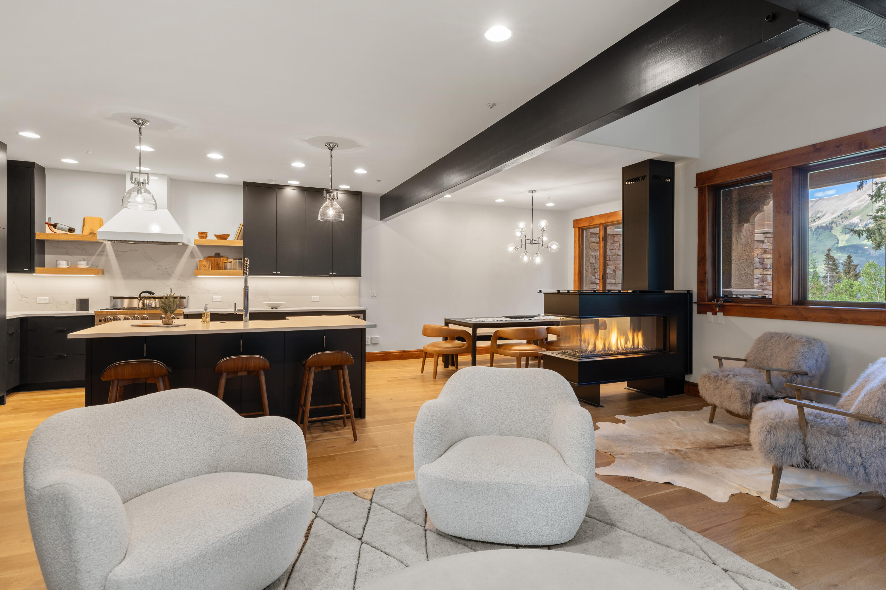 a living room with furniture kitchen view and a large window