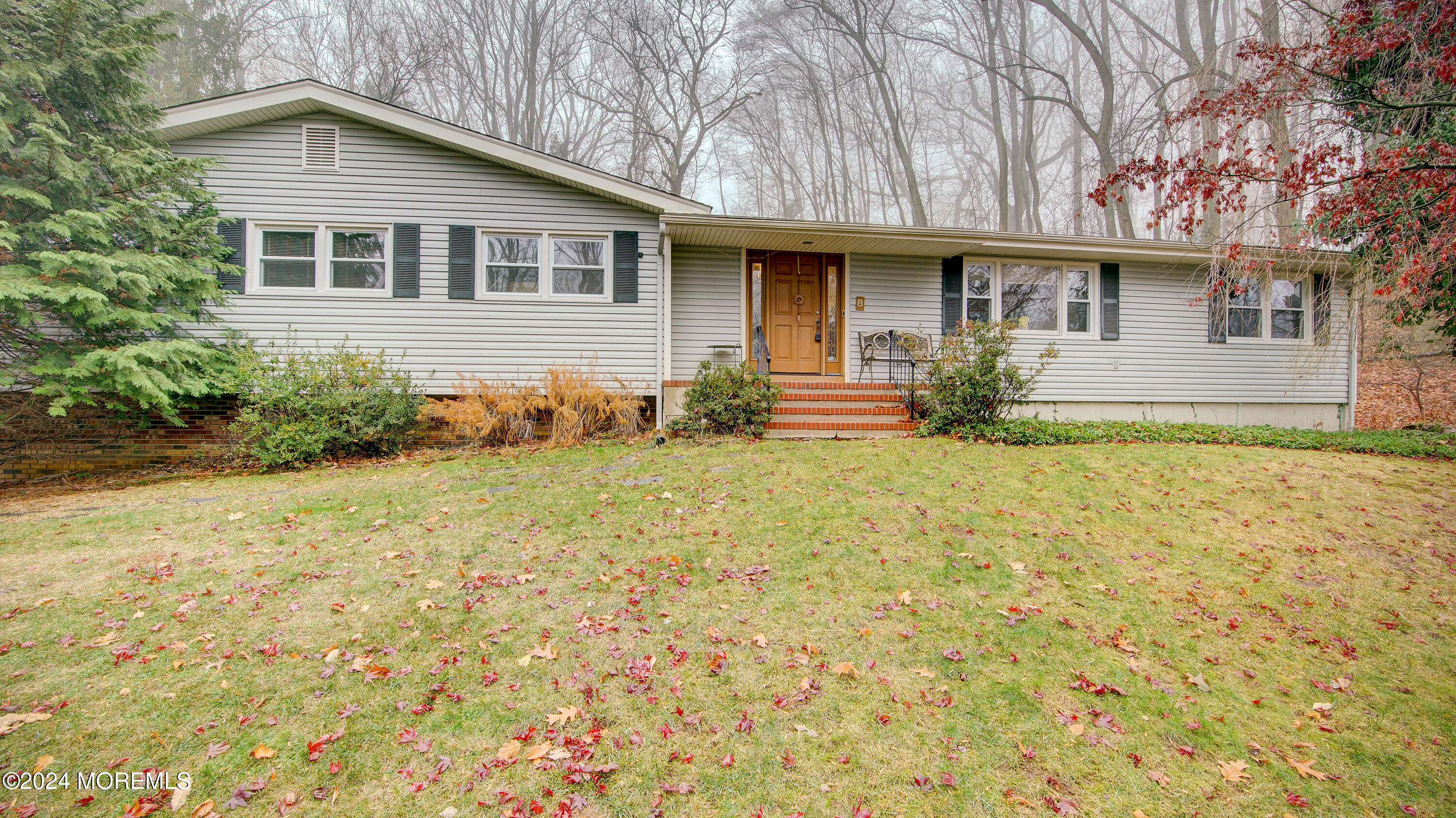 a front view of house with yard and trees around