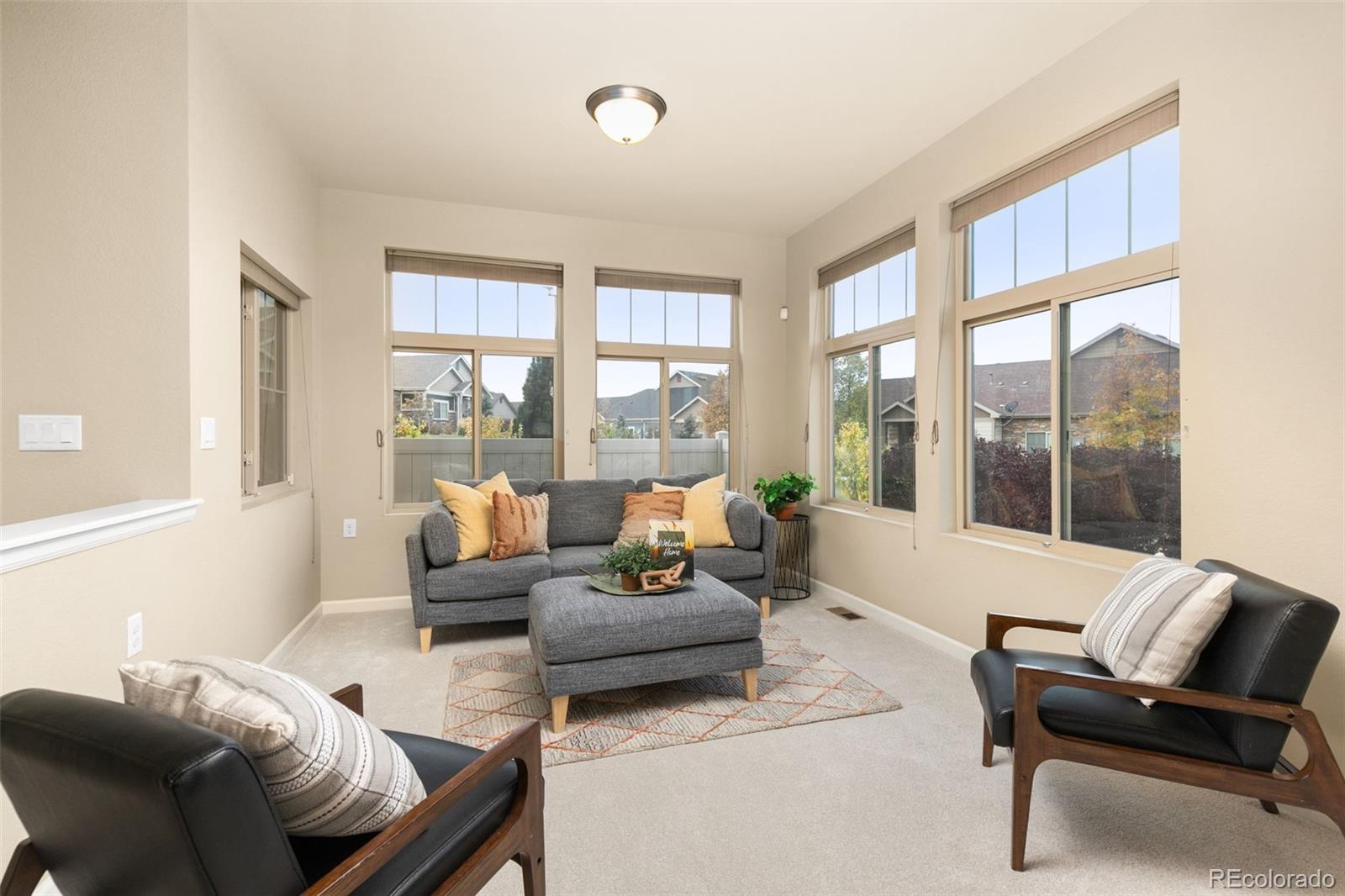 a living room with furniture and floor to ceiling windows