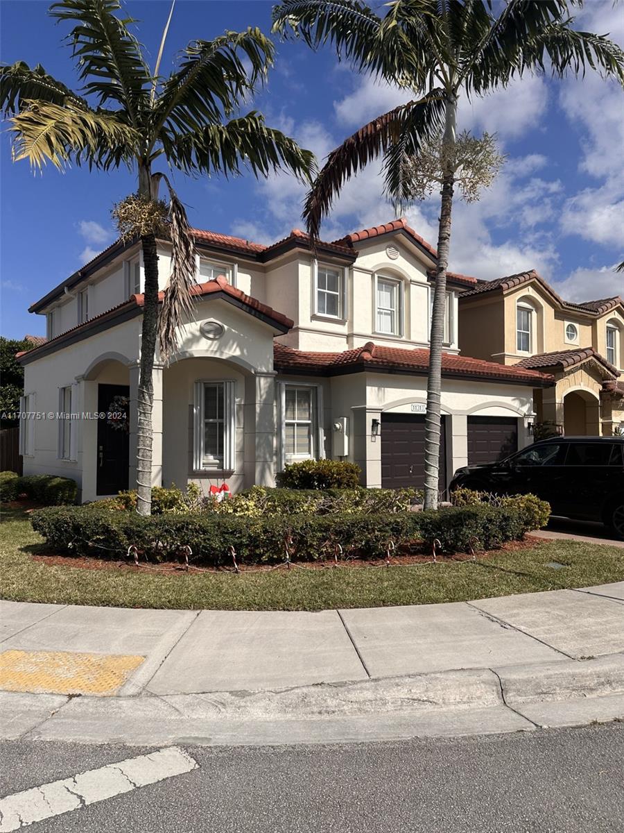 a front view of a house with a garden