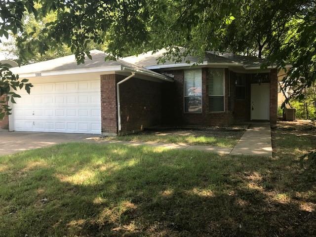 View of front facade featuring a front yard and a garage