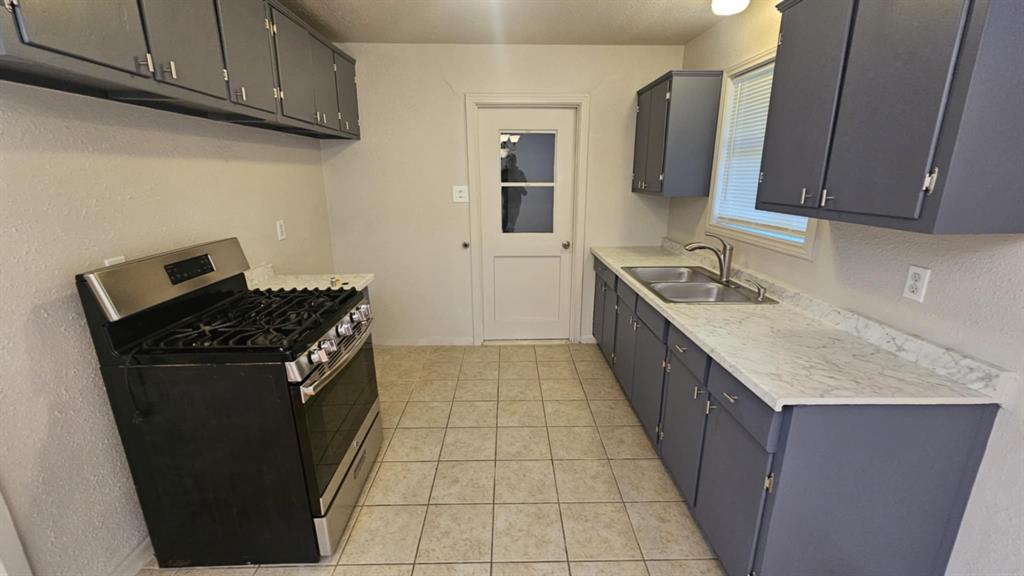 a kitchen with granite countertop a stove top oven microwave and cabinets