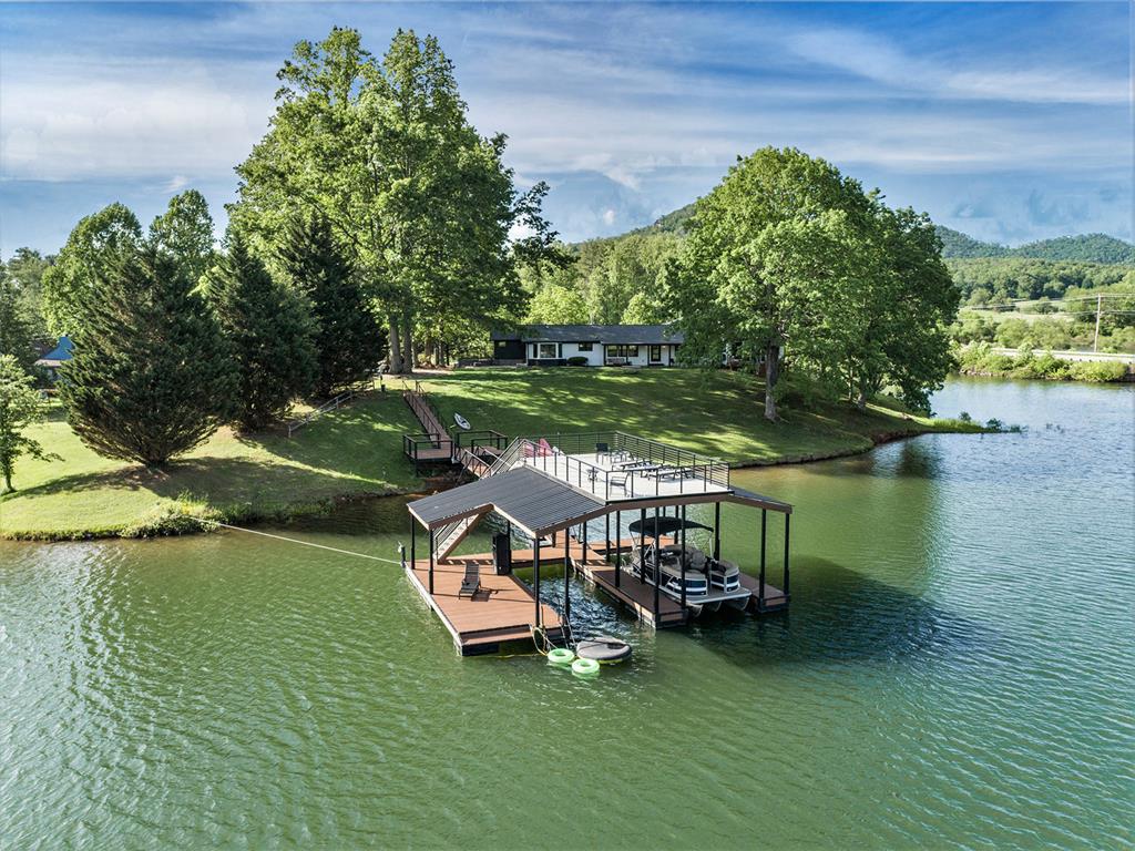 a view of a lake with lawn chairs and a table