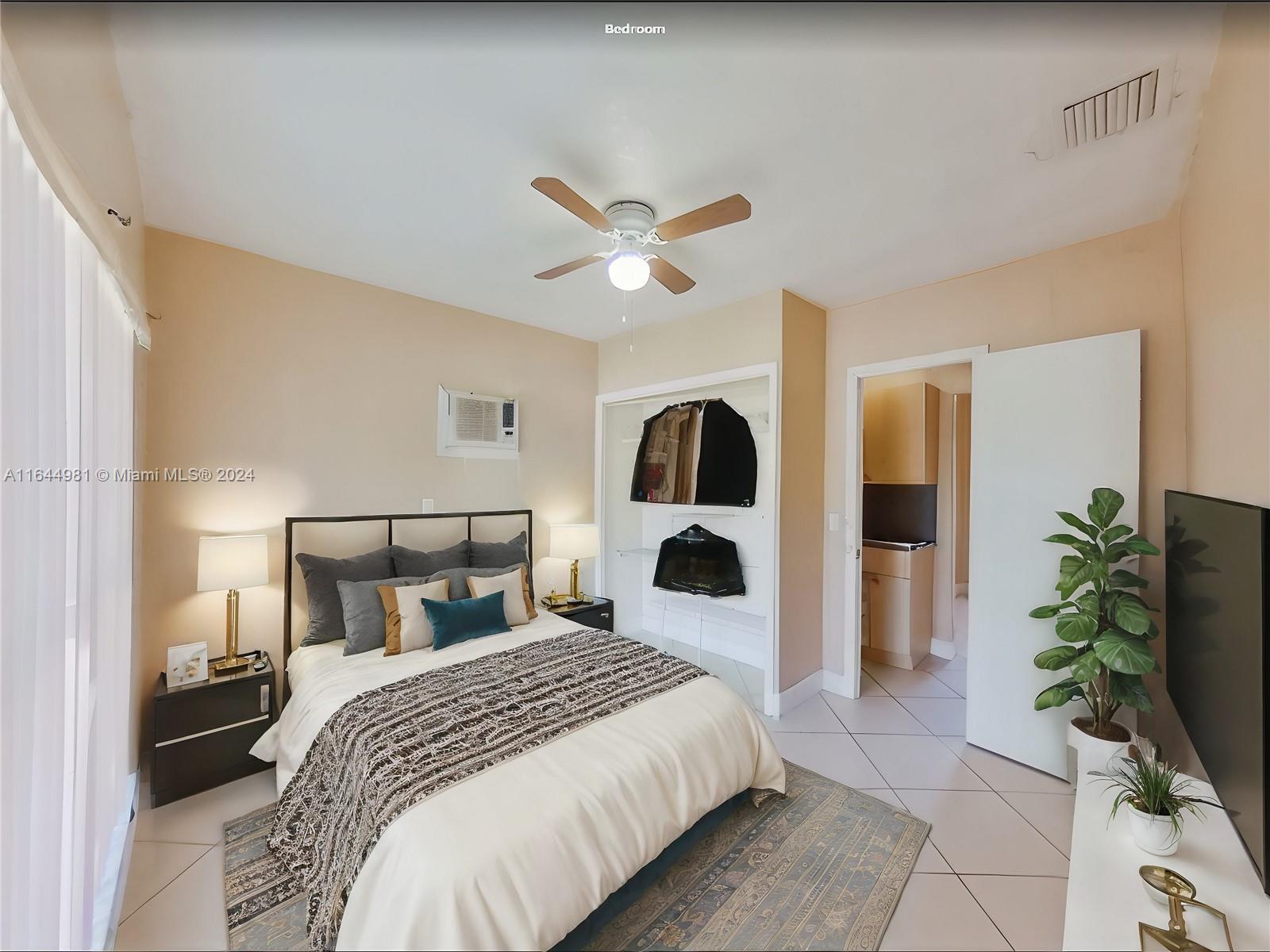 a spacious bedroom with a bed and a potted plant