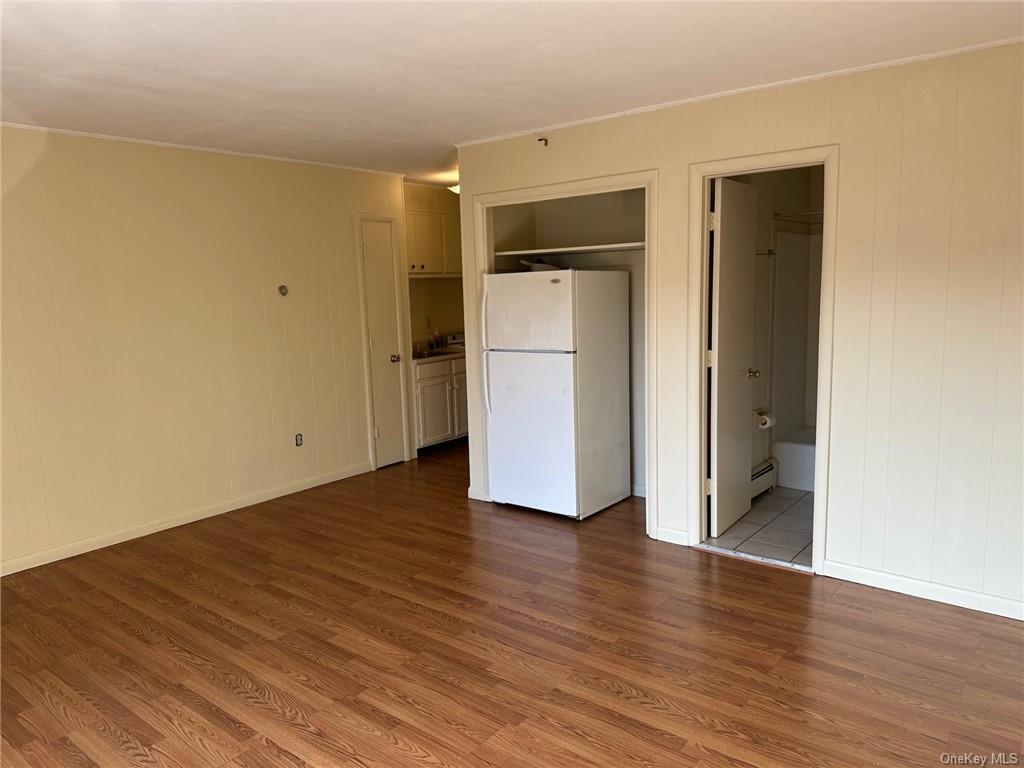 a view of a room with wooden floor and a hallway