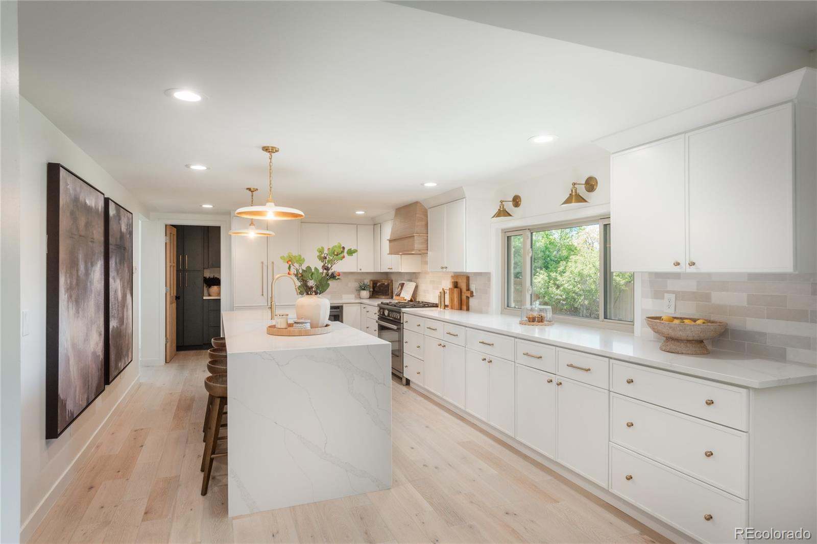 a large white kitchen with a large window