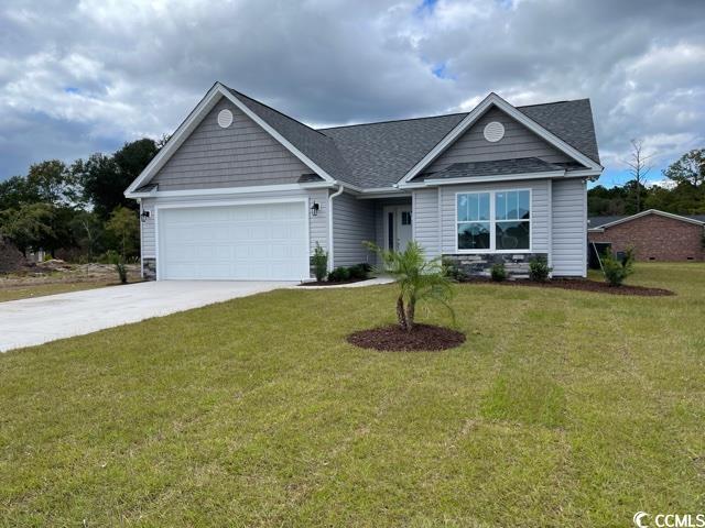 View of front of home with a garage and a front ya